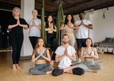 A diverse group of adults practicing yoga together indoors, focusing on mindfulness and flexibility.
