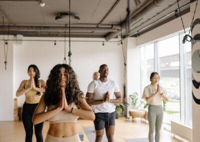 A multicultural group of adults practicing yoga poses together in a bright studio.