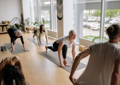 Adults practicing yoga indoors, focusing on mindfulness and flexibility exercises.